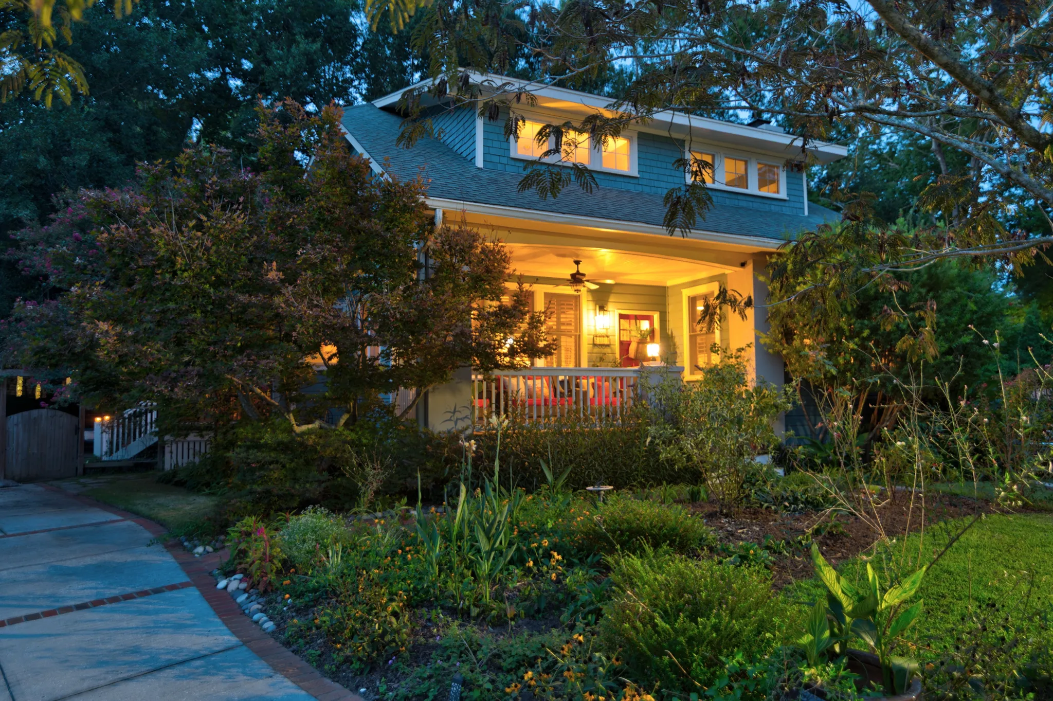 2100 Paw Paw Place, a Craftsman-style home on James Island, at twilight with the front porch lights on