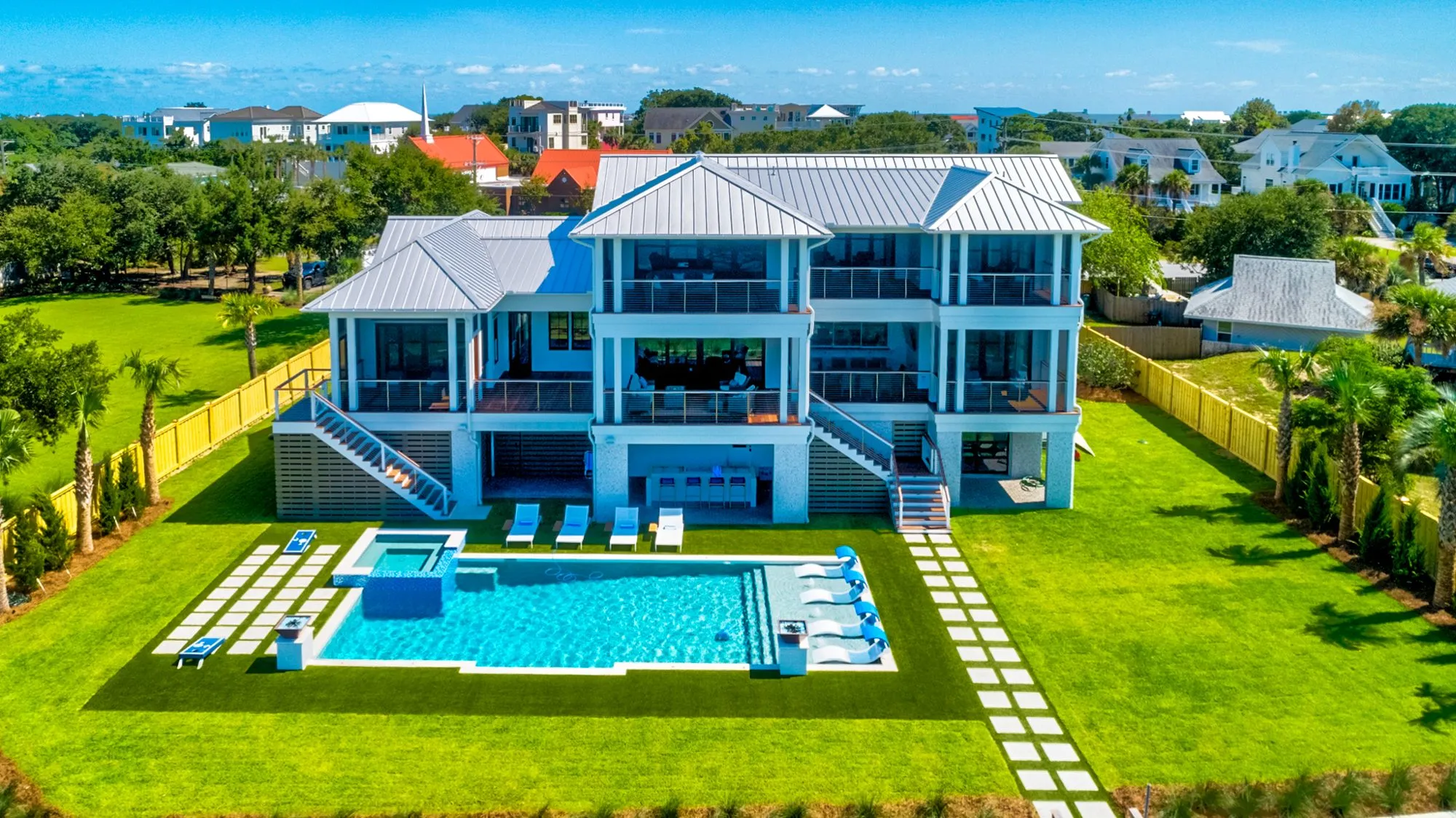 Aerial view of the back of the home, the pool and the lawn