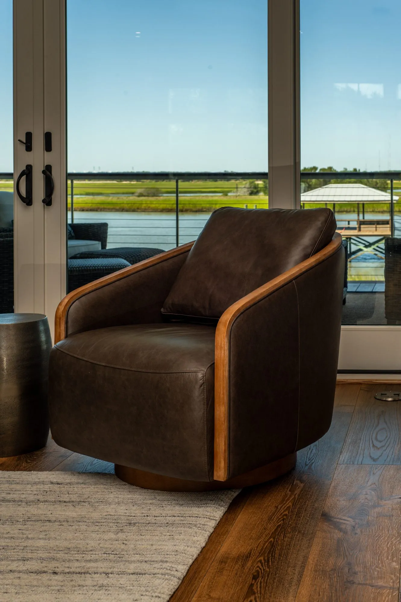 Living room with exposed beams and sliding doors opening to a marsh view